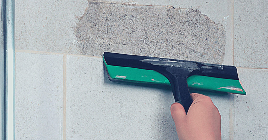 Removing Adhesive from Shower Wall by Squeegee Method